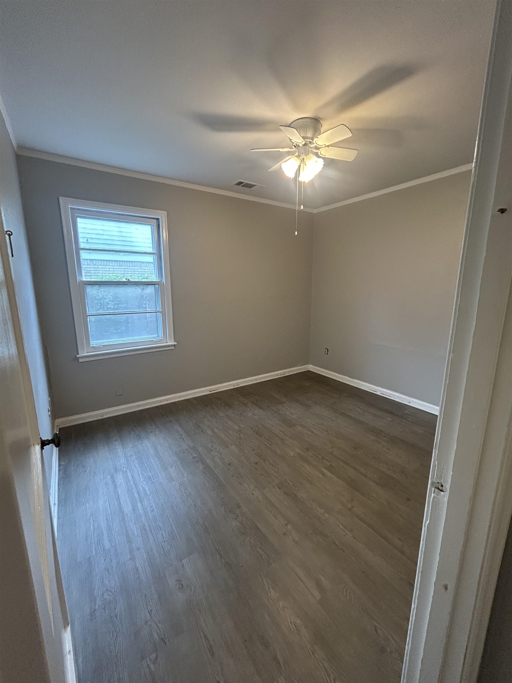 4631 Sea Isle Road Memphis, TN 38117 - Photo 19 of 28 Unfurnished room with dark wood-style flooring, baseboards, crown molding, and a ceiling fan