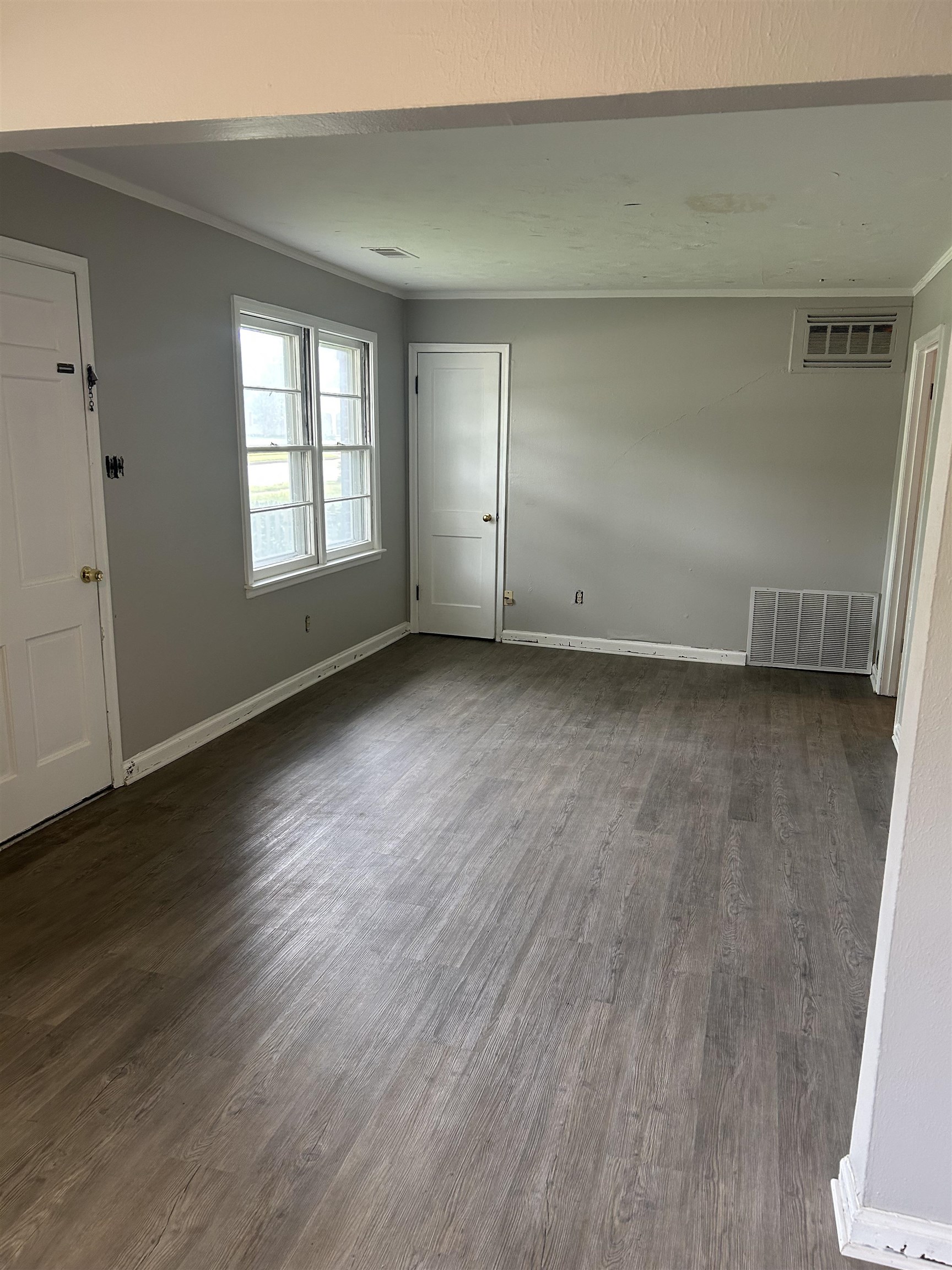 4631 Sea Isle Road Memphis, TN 38117 - Photo 4 of 28 Empty room with dark wood-type flooring, baseboards, and crown molding