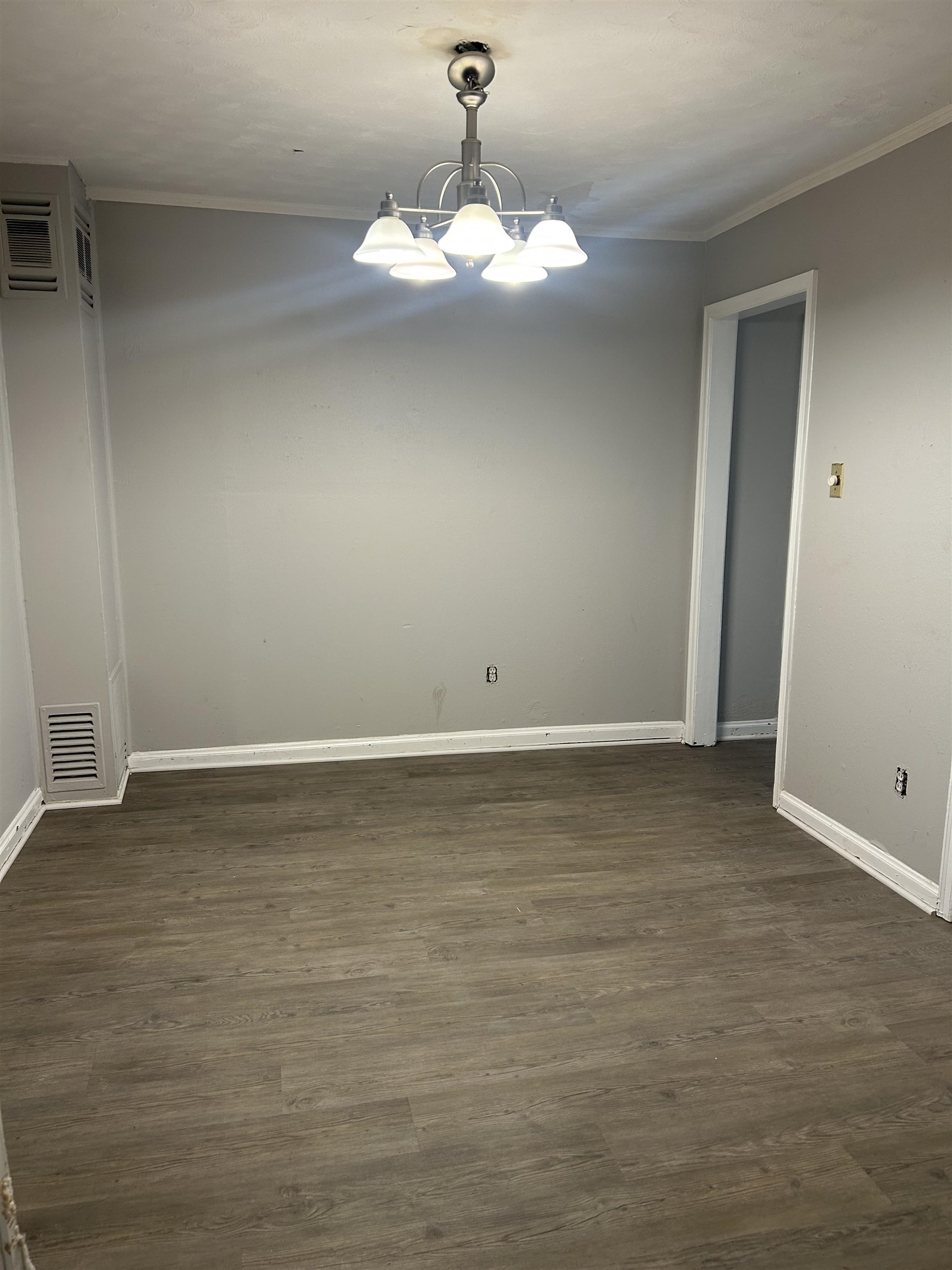 4631 Sea Isle Road Memphis, TN 38117 - Photo 10 of 28 Empty room with ornamental molding, a chandelier, baseboards, and dark wood finished floors