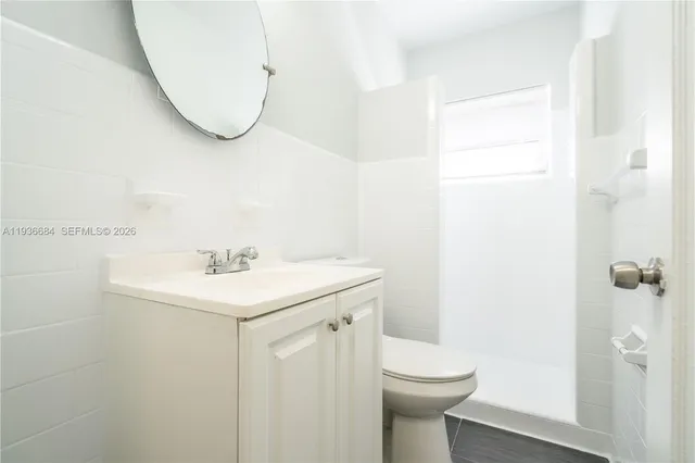 a bathroom with a sink a toilet and a mirror