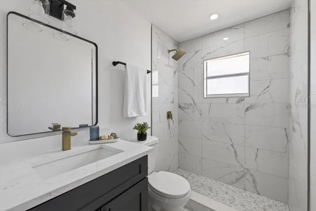 a bathroom with a sink a toilet and shower