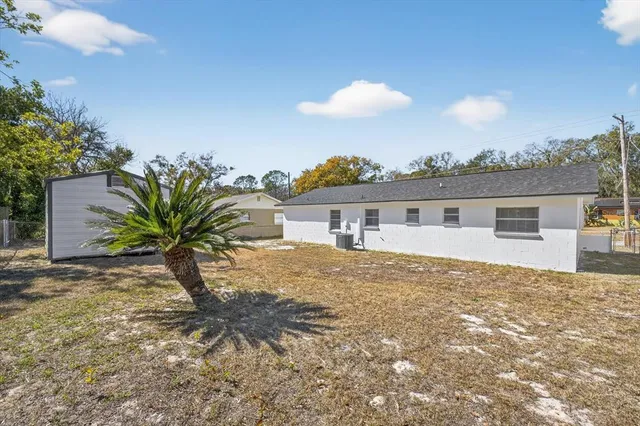 a view of a house with a yard and potted plants