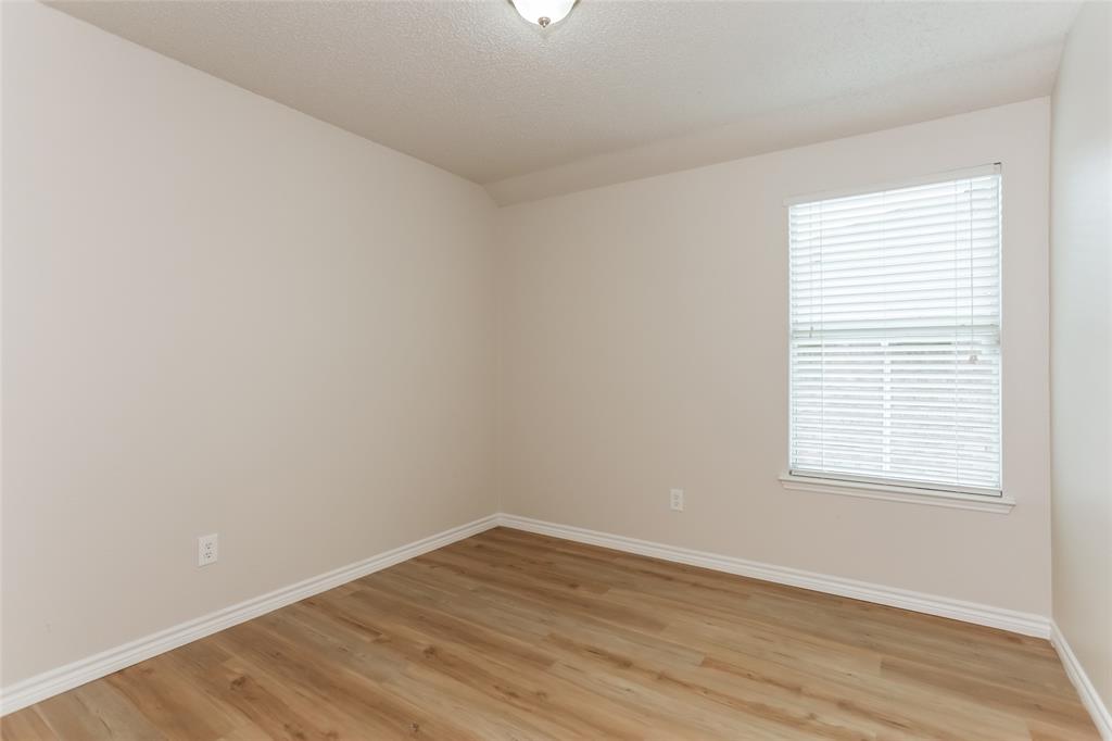 1019 Chelsea Lane Forney, TX 75126 - Photo 11 of 16 an empty room with wooden floor and windows