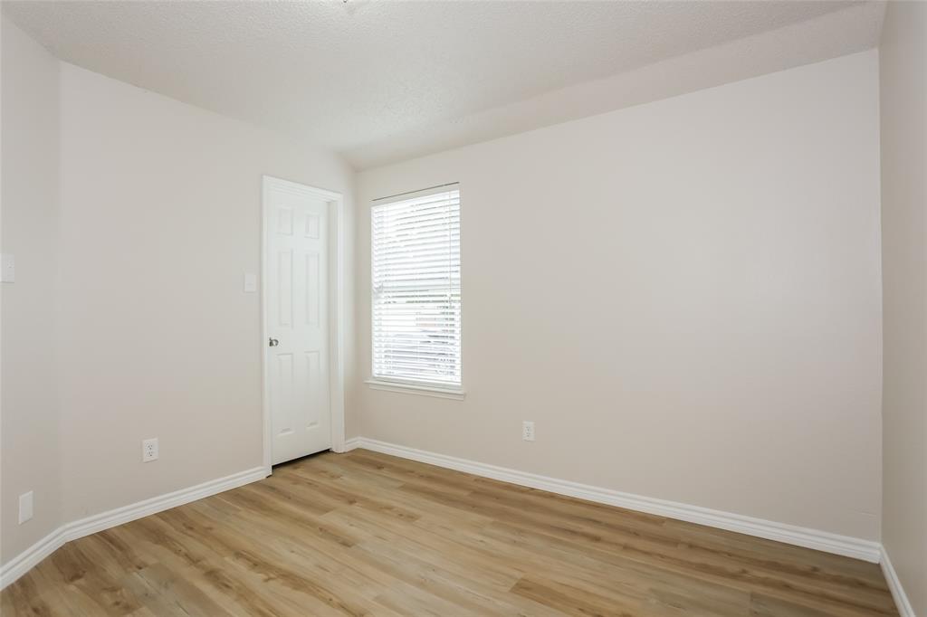 1019 Chelsea Lane Forney, TX 75126 - Photo 12 of 16 a view of an empty room with wooden floor and a window