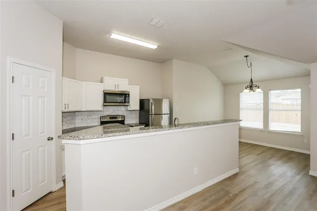 a kitchen with stainless steel appliances granite countertop a sink a stove top oven a counter space and cabinets