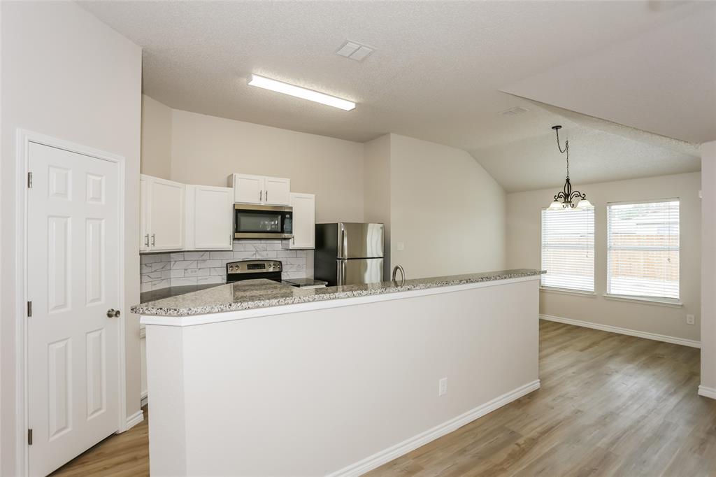 1019 Chelsea Lane Forney, TX 75126 - Photo 5 of 16 a kitchen with stainless steel appliances granite countertop a sink a stove top oven a counter space and cabinets