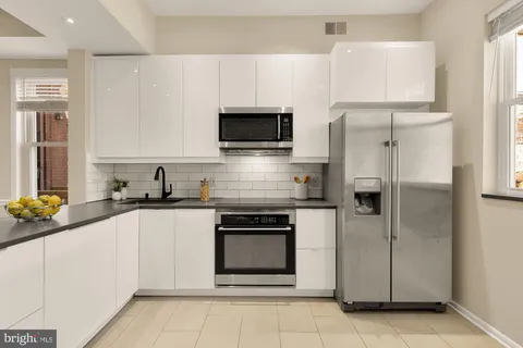 a kitchen with cabinets stainless steel appliances and a window