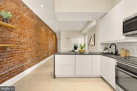 a kitchen with stainless steel appliances a sink a stove top oven a counter space and cabinets