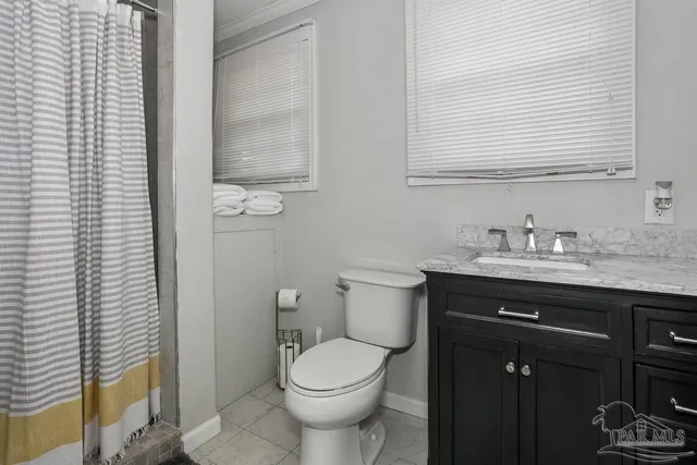 a bathroom with a granite countertop toilet a sink and a mirror