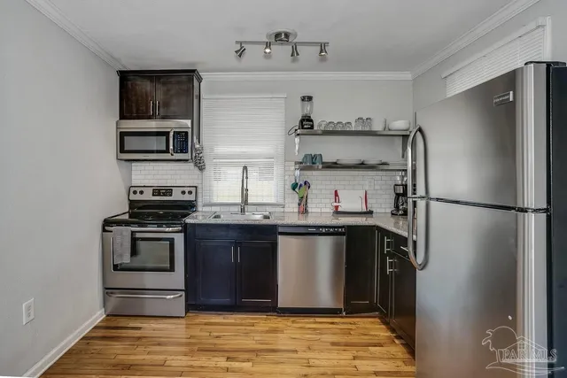 a kitchen with stainless steel appliances granite countertop a refrigerator and a stove