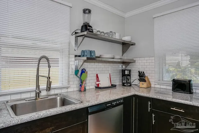 a kitchen with stainless steel appliances a sink a stove and cabinets
