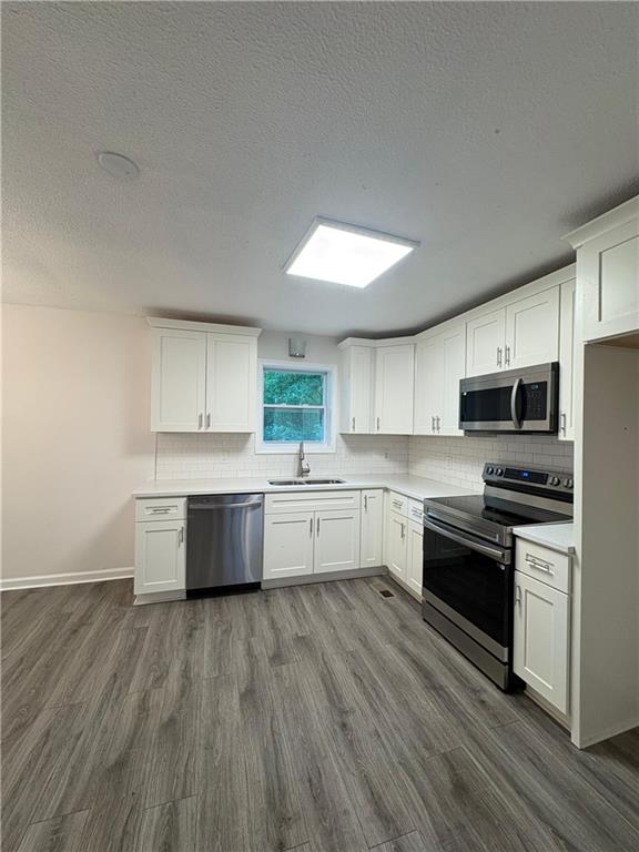 643 Akins Road Chickamauga, GA 30707 - Photo 7 of 14 a kitchen with stainless steel appliances white cabinets and wooden floors
