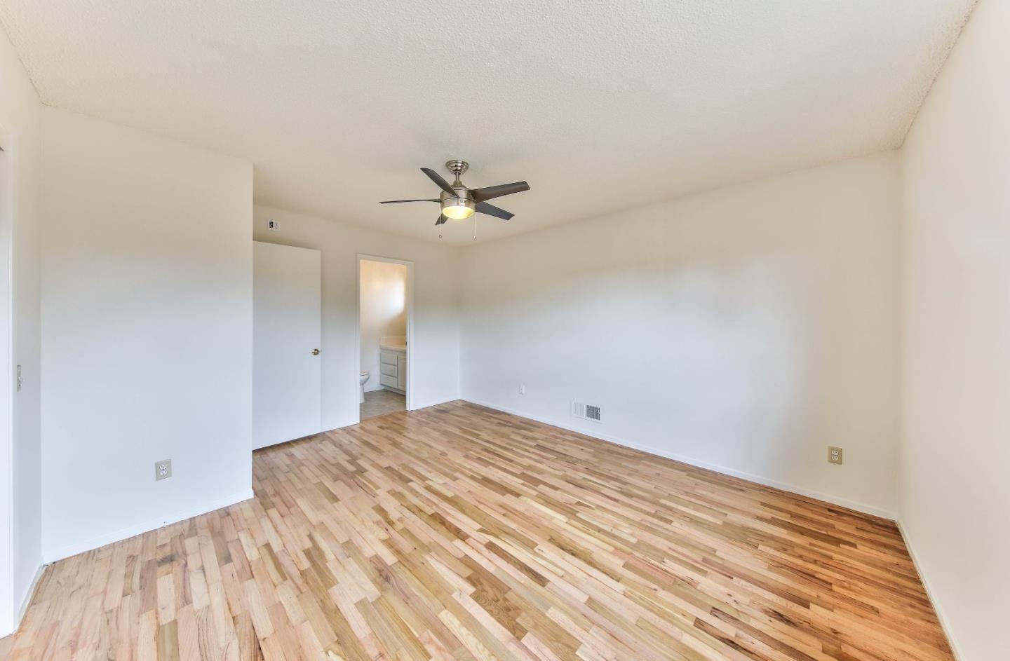 3283 Michael Drive Marina, CA 93933 - Photo 12 of 19 a view of a bedroom with a bed and a chandelier fan