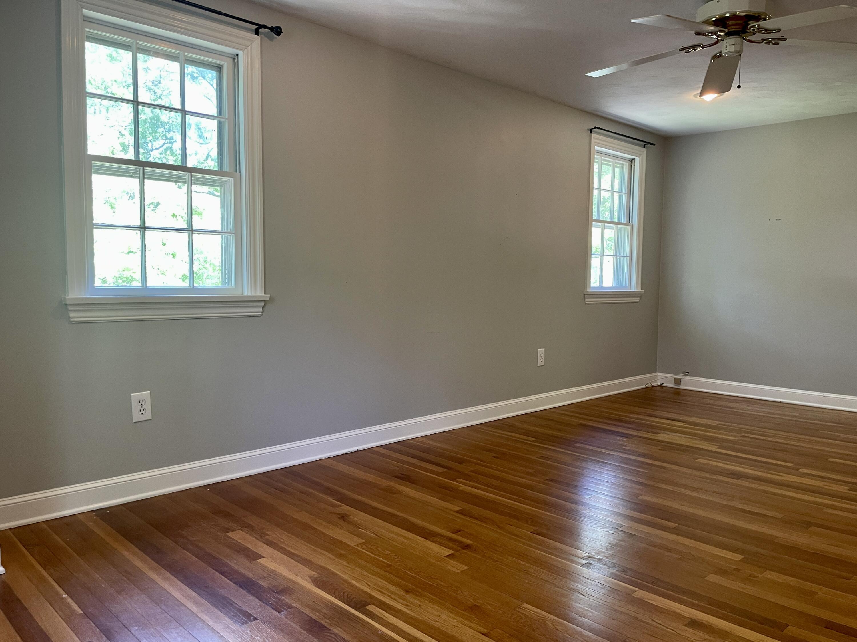 42 Forest Drive Mashpee, MA 02649 - Photo 20 of 55 an empty room with wooden floor a chandelier fan and windows