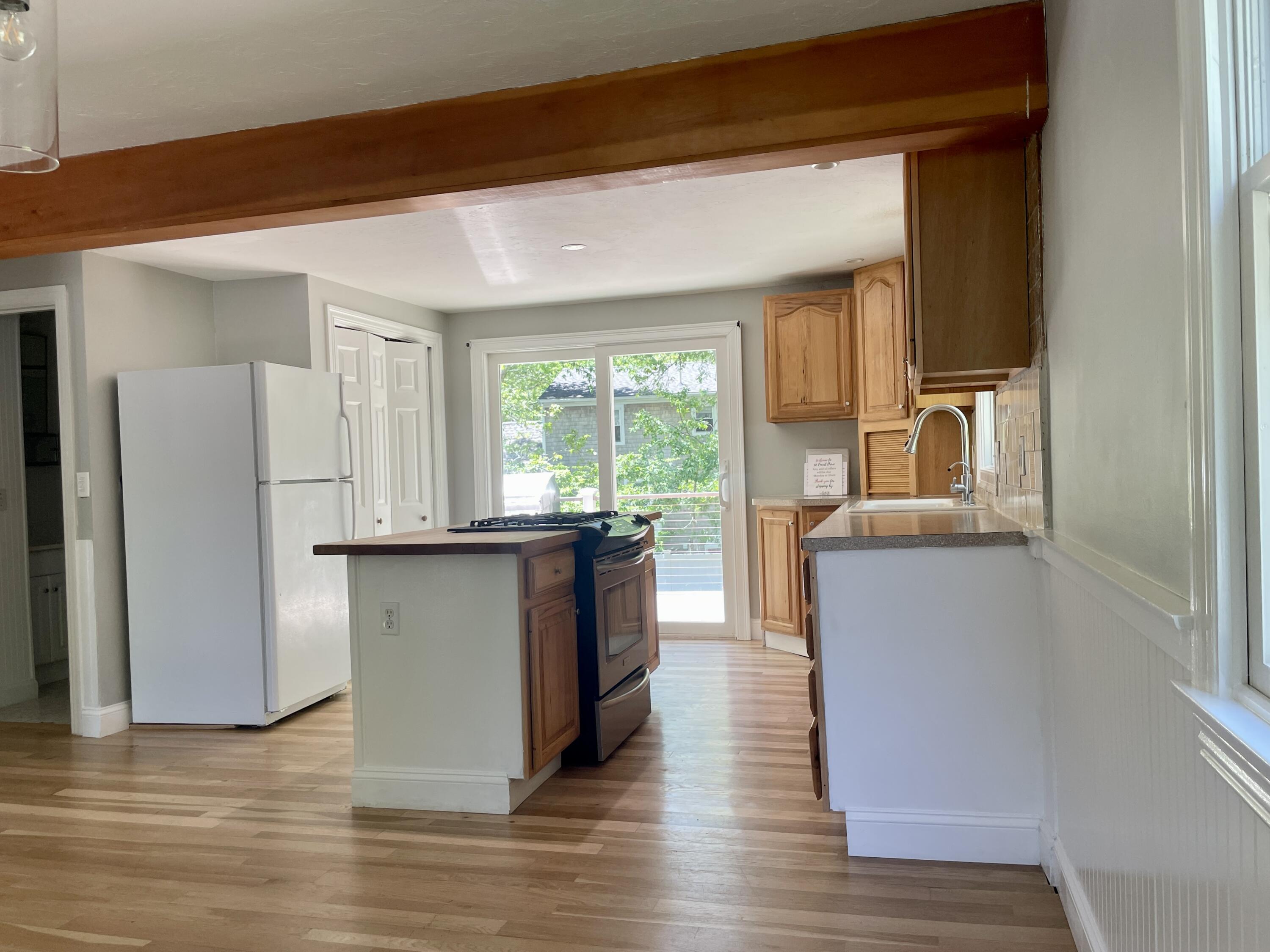 42 Forest Drive Mashpee, MA 02649 - Photo 6 of 55 a kitchen with stainless steel appliances granite countertop a refrigerator a sink dishwasher a stove and white countertops with wooden floor