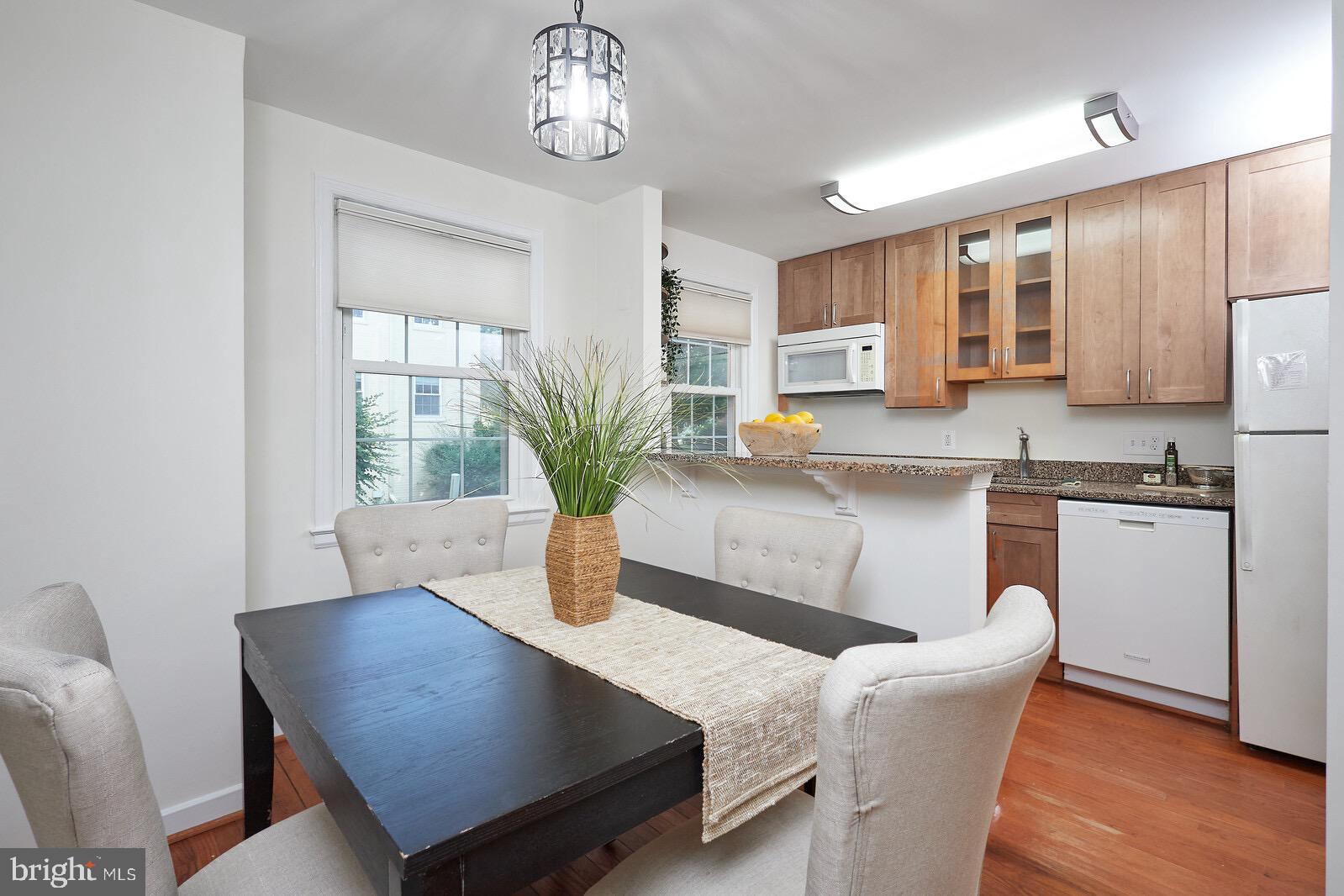 2215 Washington Avenue, Unit 103 Silver Spring, MD 20910 - Photo 6 of 26 a kitchen with a table chairs and refrigerator