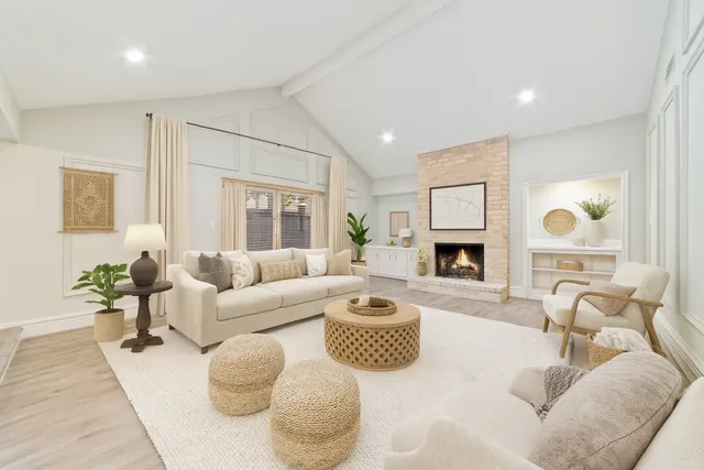 a living room with furniture fireplace and a large window