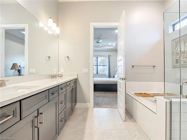 a spacious bathroom with a tub sink and mirror