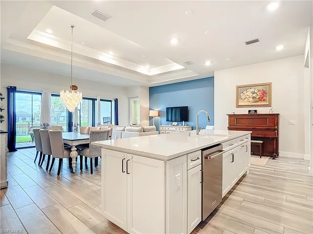 a large kitchen with kitchen island a sink table and chairs
