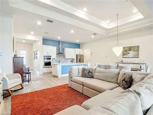 a living room with furniture wooden floor and kitchen view