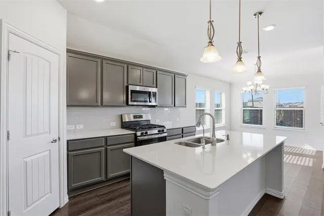 a kitchen with kitchen island a sink appliances and cabinets