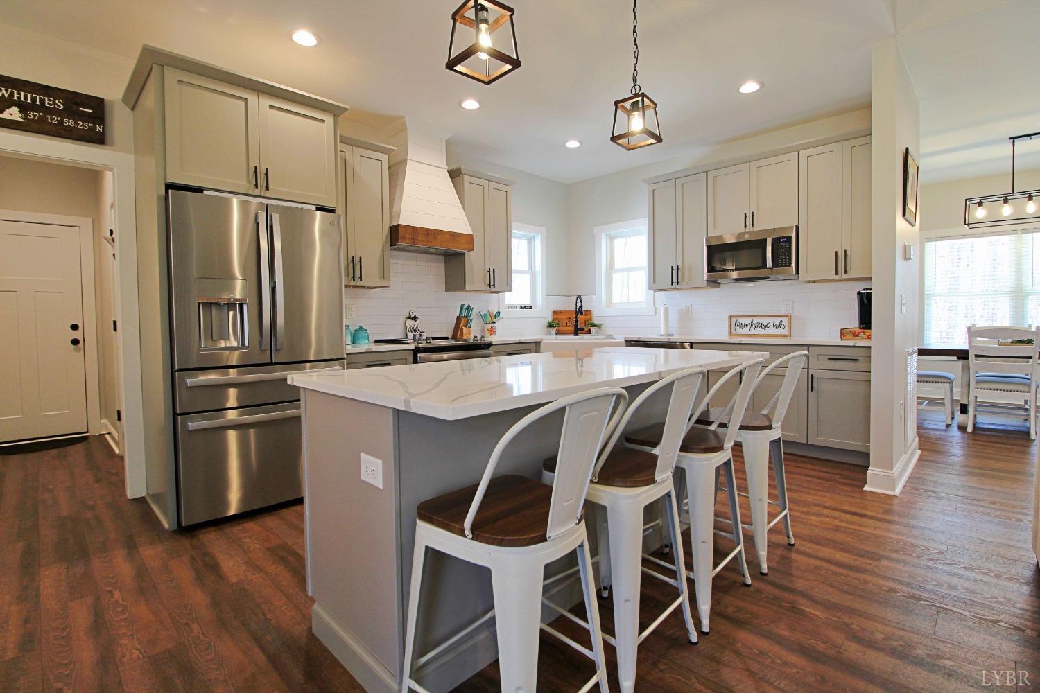 45 Langdon Road Evington, VA 24550 - Photo 19 of 74 a kitchen with granite countertop stainless steel appliances a refrigerator a stove a sink a dining table and chairs with wooden floor