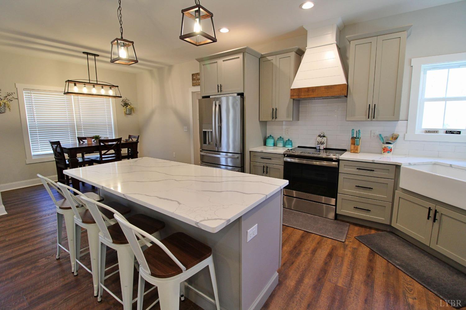 45 Langdon Road Evington, VA 24550 - Photo 27 of 74 a kitchen with stainless steel appliances a dining table chairs sink and wooden floor