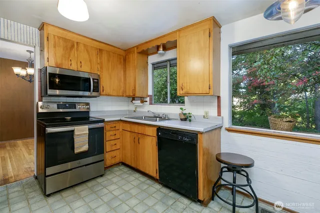 a kitchen with stainless steel appliances a stove a sink and a microwave