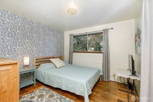 a bedroom with a bed and wooden floor