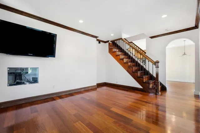 a view of a hallway with wooden floor and windows