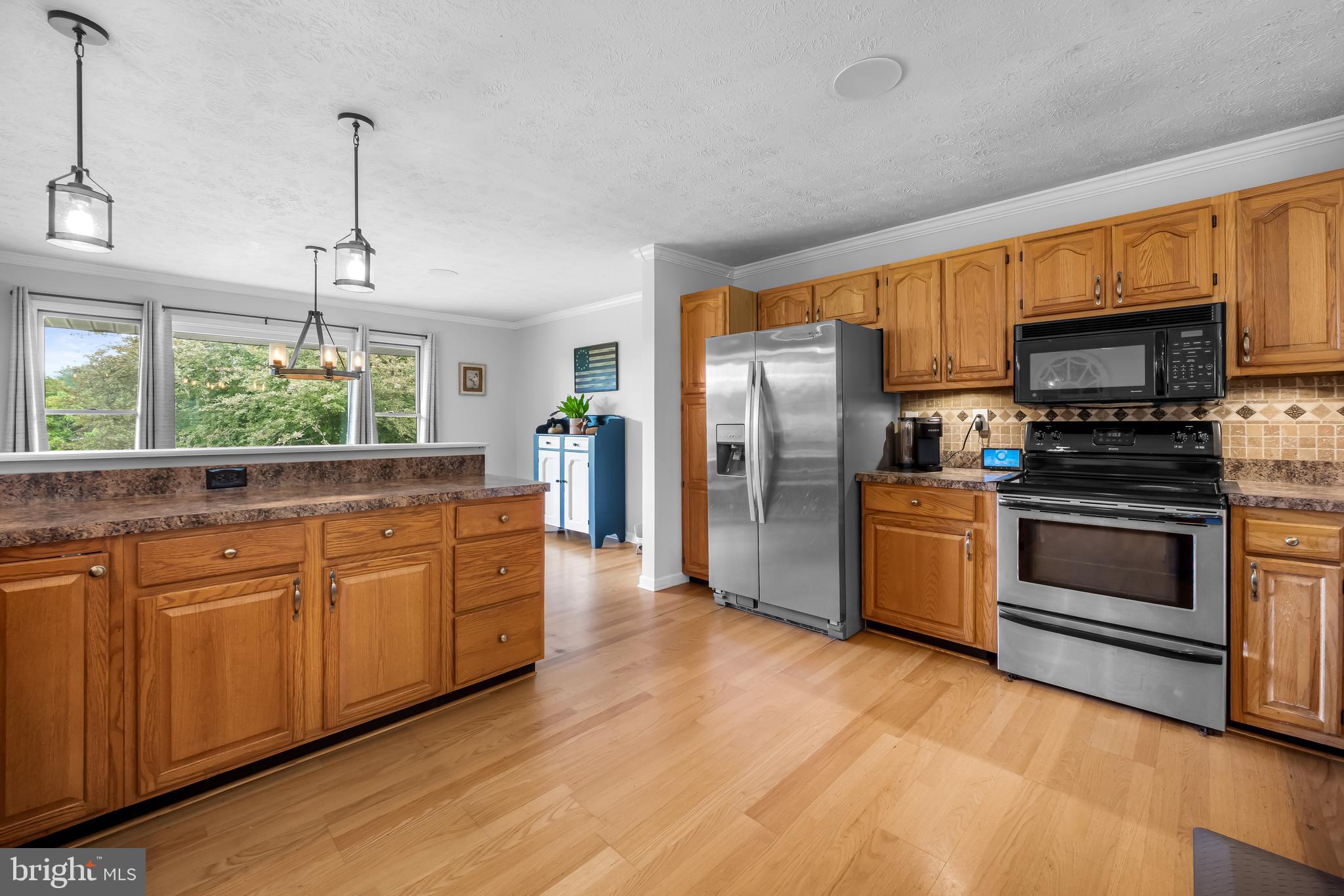 2997 Patapsco Road Finksburg, MD 21048 - Photo 6 of 50 a kitchen with stainless steel appliances kitchen island granite countertop a stove a sink and a refrigerator