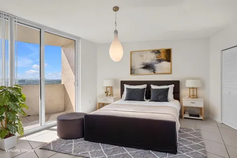 a bedroom with a large bed and a potted plant