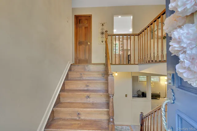 a view of staircase with white walls and a painting on the wall