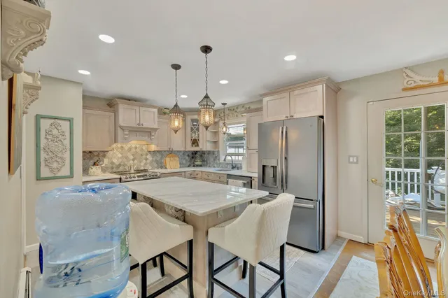 a kitchen with stainless steel appliances granite countertop table chairs refrigerator and microwave