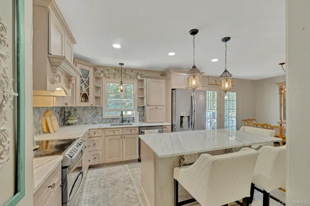 a kitchen with kitchen island a sink stove and refrigerator