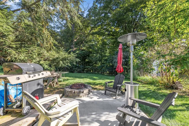 a view of a backyard with table and chairs potted plants and swimming pool