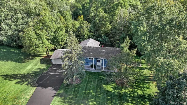 a aerial view of a house with a yard and large trees