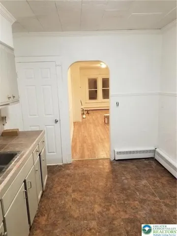 an empty room with wooden floor and cabinet