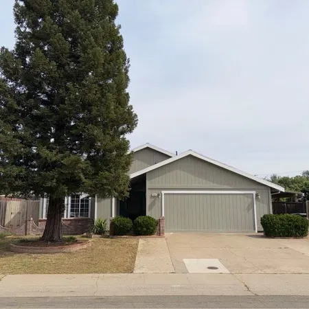 a front view of house with yard and trees around