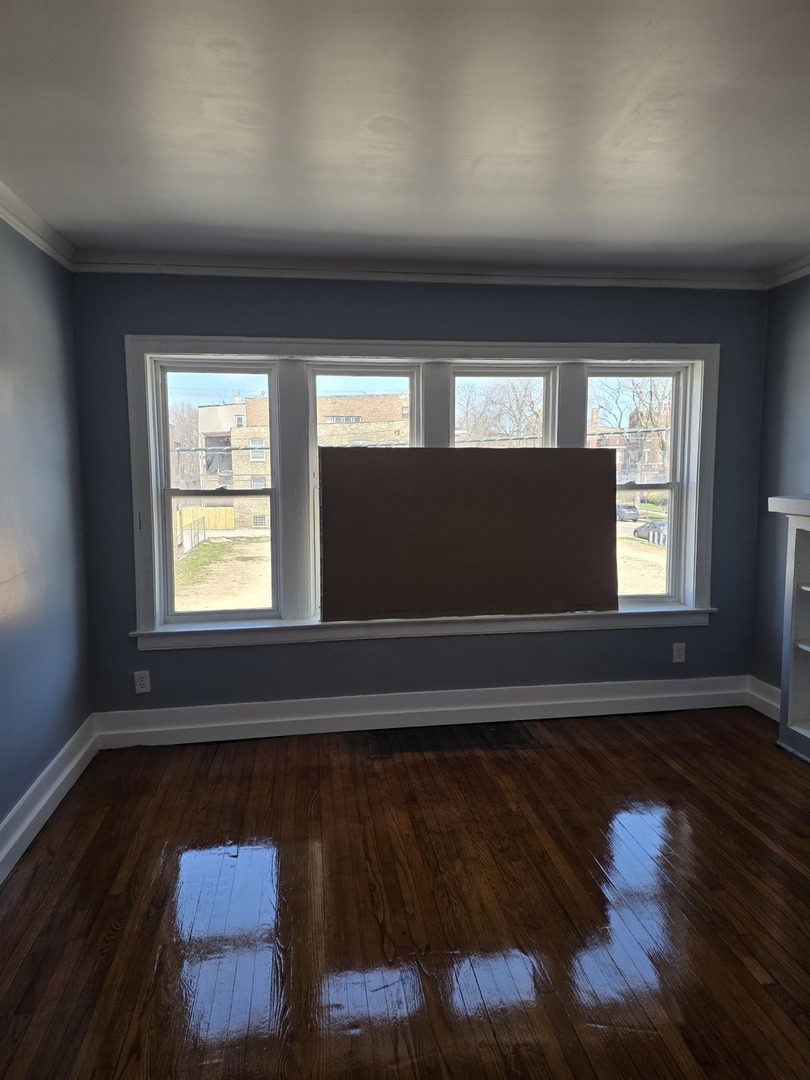 1853 East 79th Street, Unit 2 Chicago, IL 60649 - Photo 4 of 14 an empty room with wooden floor and windows