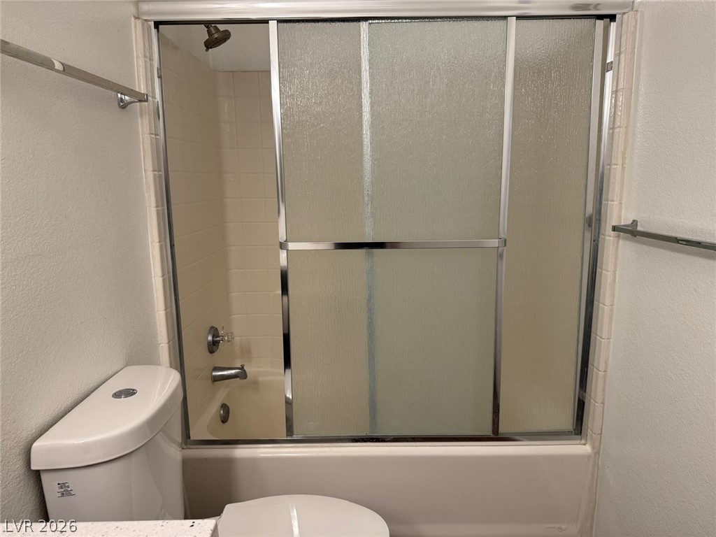 7885 West Flamingo Road, Unit 2171 Las Vegas, NV 89147 - Photo 18 of 22 A well-maintained bathroom offers a classic tub and shower combination with sliding frosted glass doors.