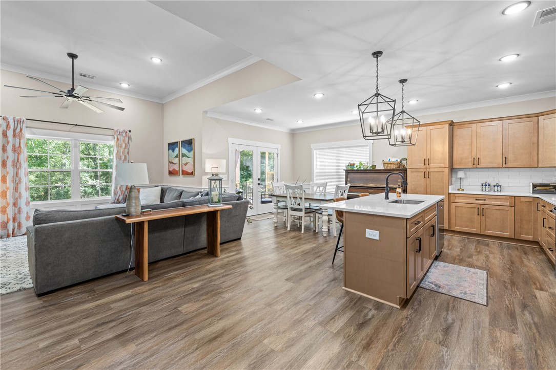 322 Thompson Street Pendleton, SC 29670 - Photo 16 of 38 Warm flooring flows through a versatile open layout connecting the kitchen and living areas.