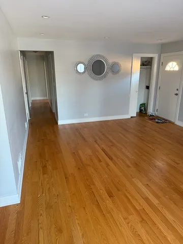 a view of a livingroom with wooden floor and staircase