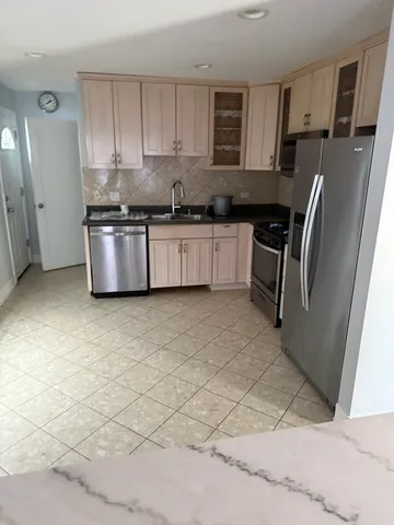 a kitchen with stainless steel appliances granite countertop a stove a sink a microwave and a refrigerator