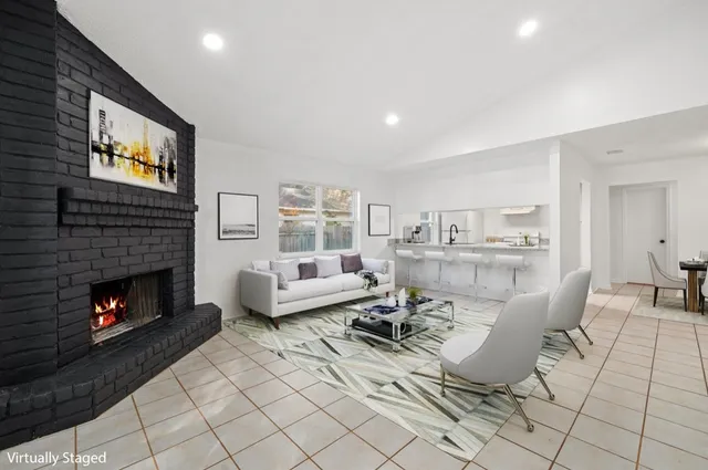 a living room with furniture a flat screen tv and a fireplace