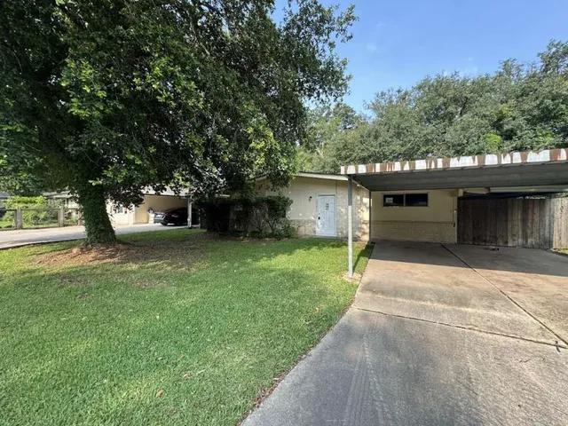 a front view of a house with a garden and trees