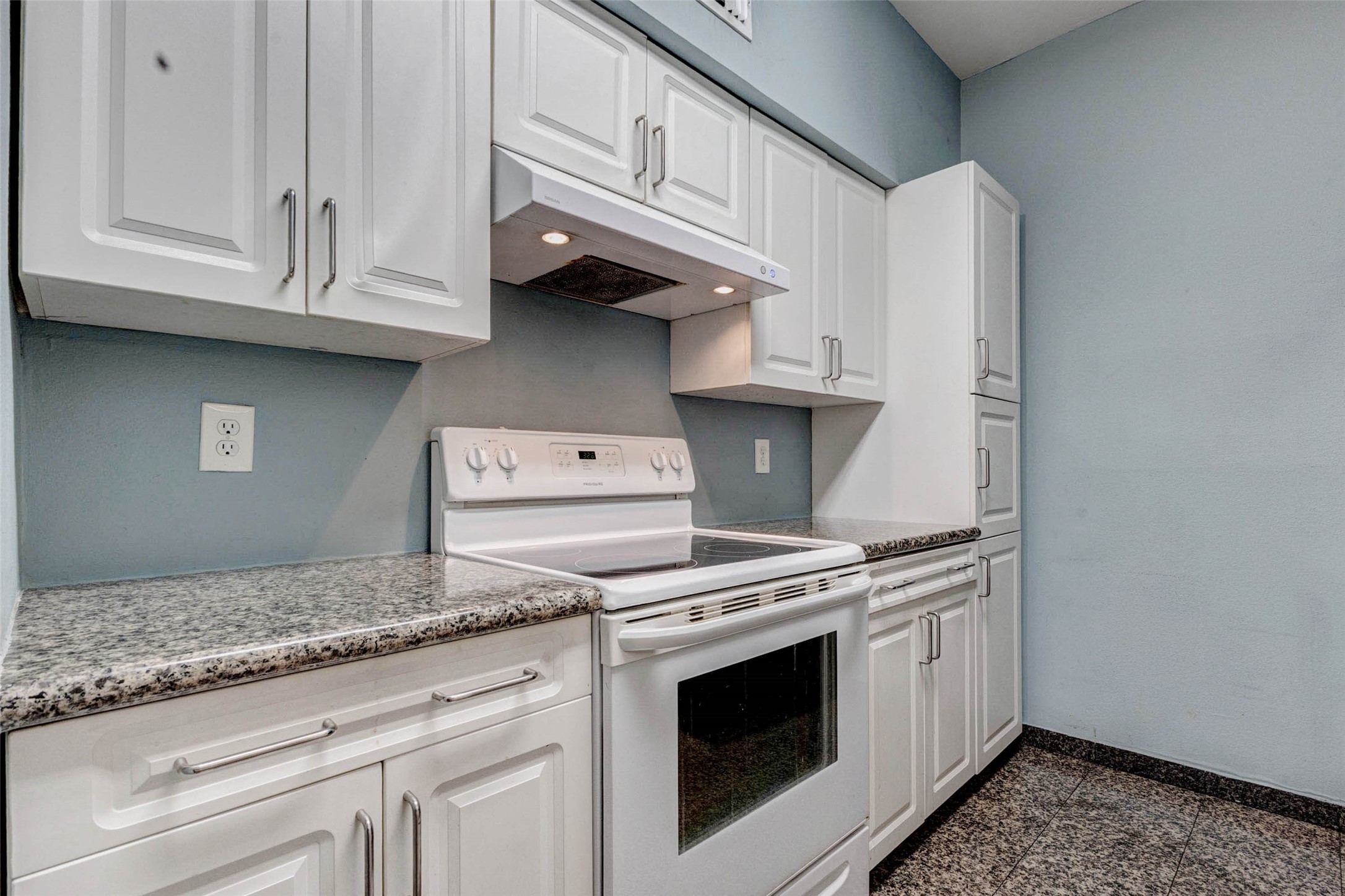 3800 Tanglewilde Street, Unit 102 Houston, TX 77063 - Photo 6 of 28 a kitchen with granite countertop white cabinets and appliances