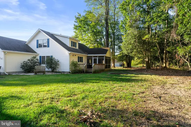 a view of house with deck outdoor seating and trees