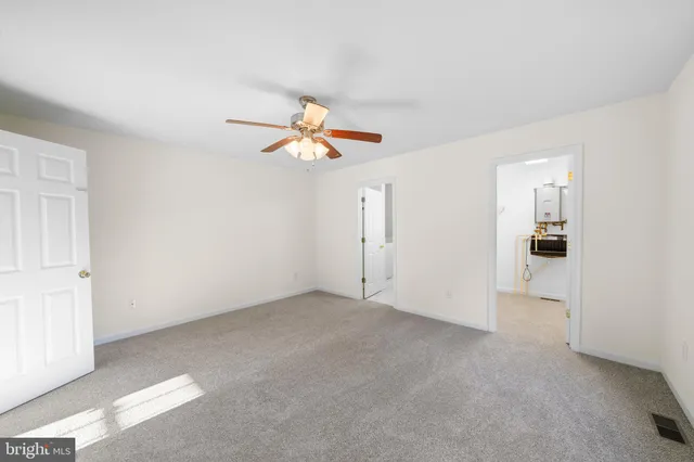 an empty room with windows and chandelier fan