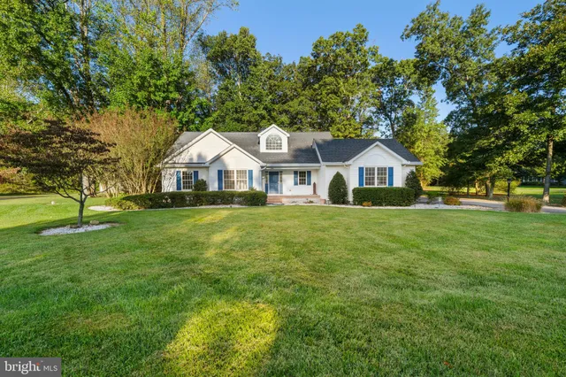 a front view of a house with a yard and trees